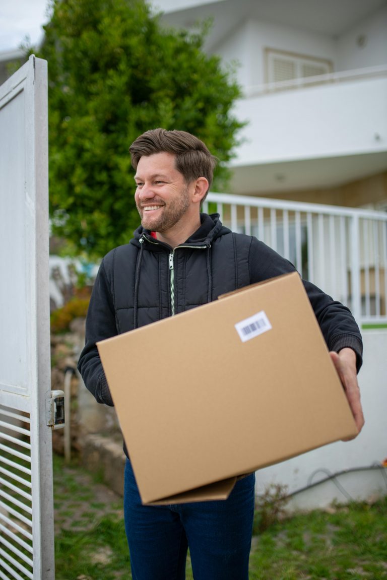 Man in hoodie carrying a box